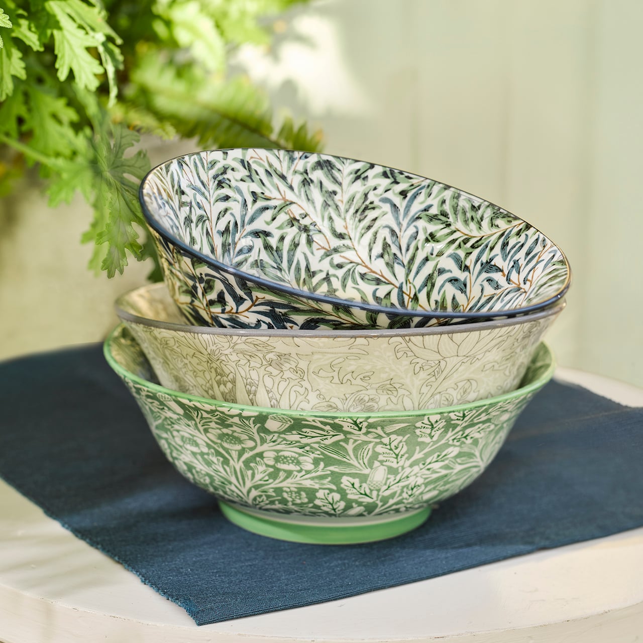 Stacked ceramic bowls with green and blue leafy designs