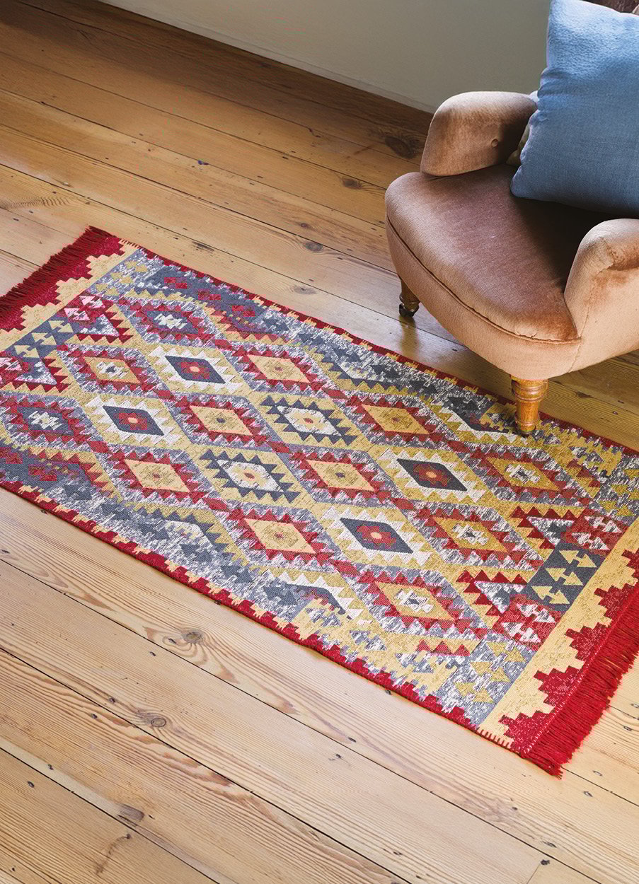 Red tapestry style rug on wooden floor