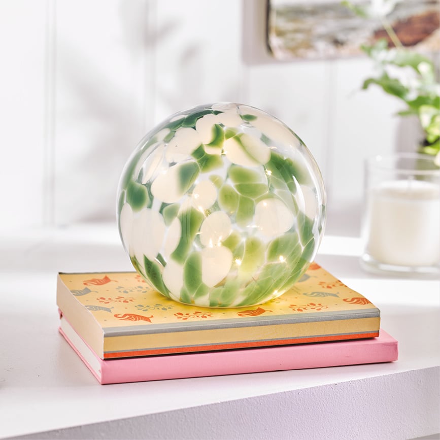 Round painted ball lamp on pile of books