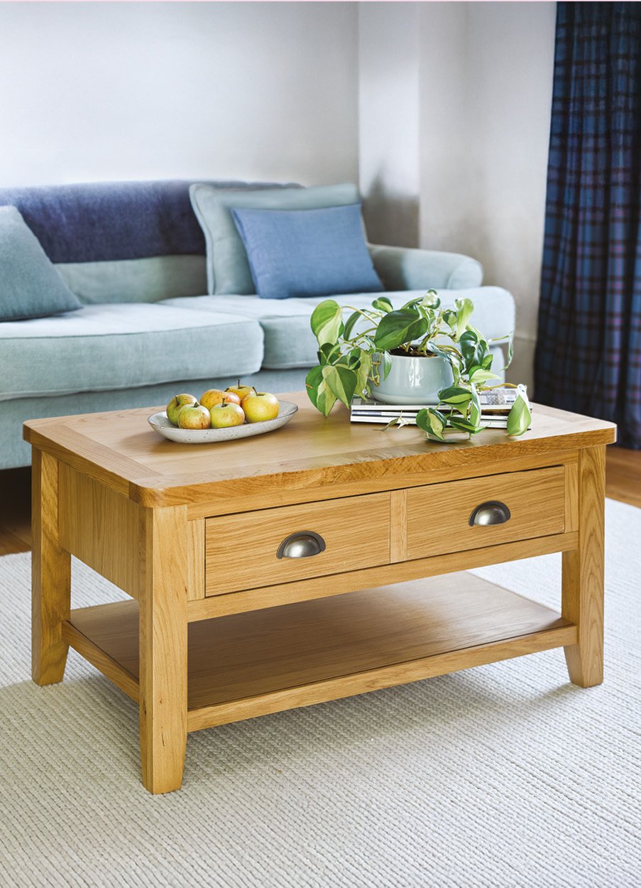 Oak coffee table with fruit bowl in front of blue sofa