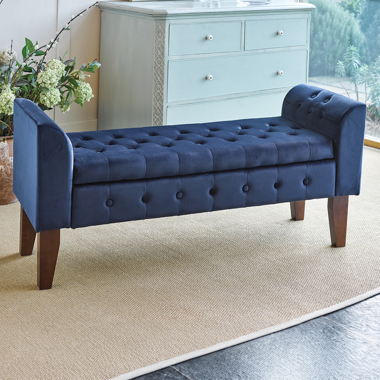 Navy blue upholstered storage bench with mahogany legs