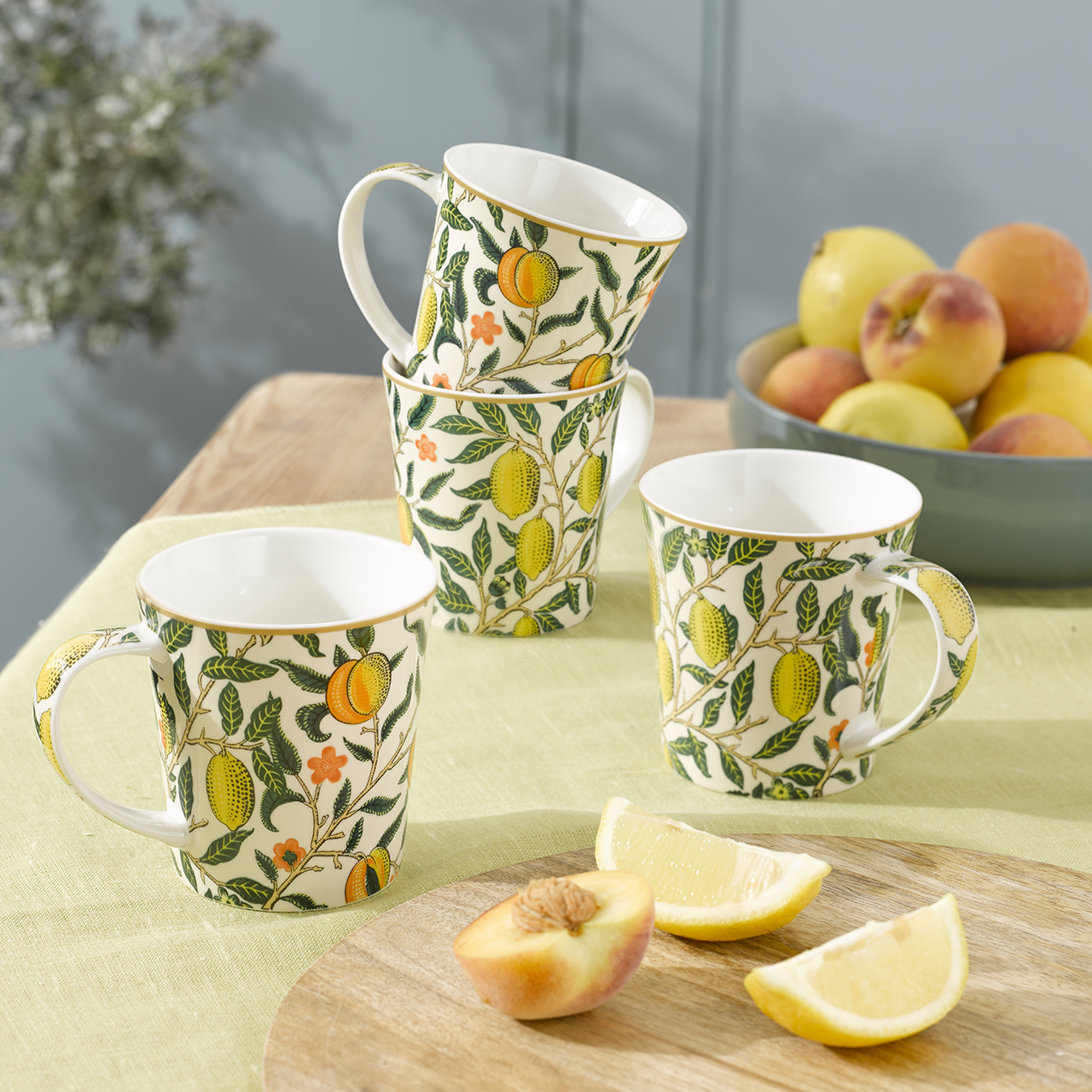 Four fruit‑patterned mugs arranged on a table