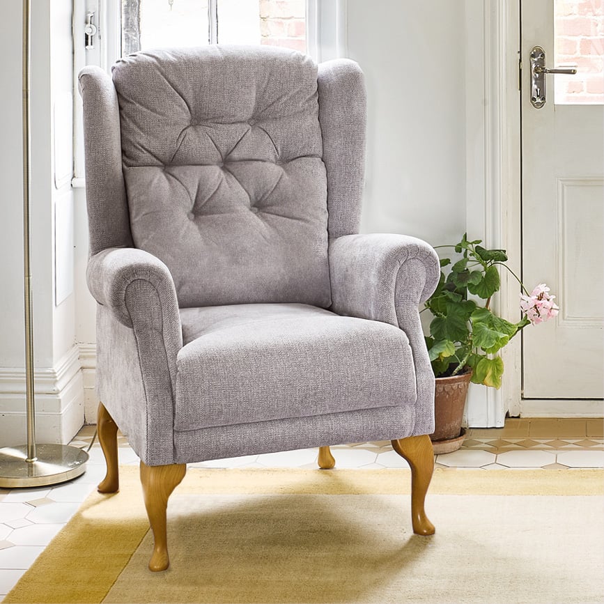 Grey upholstered armchair in bright living room